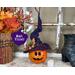 This image shows a Halloween witch decoration. It is made from a real dried gourd. Her name is Violet and has a purple witch hat. 